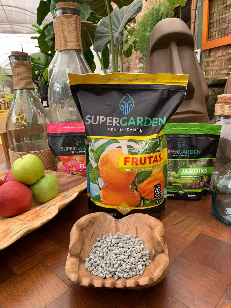Embalagens de fertilizante Super Garden para frutas e jardim, expostas sobre tábua de madeira com os grânulos à mostra
